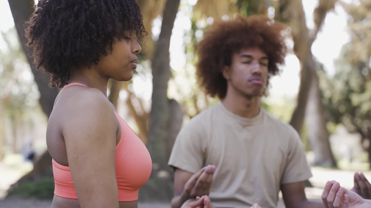 pareja centrada meditando en la postura del loto en el parque