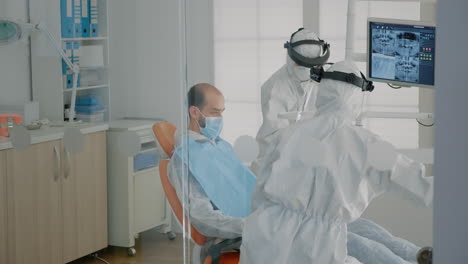 dentistry staff wearing ppe suits doing teethcare consultation