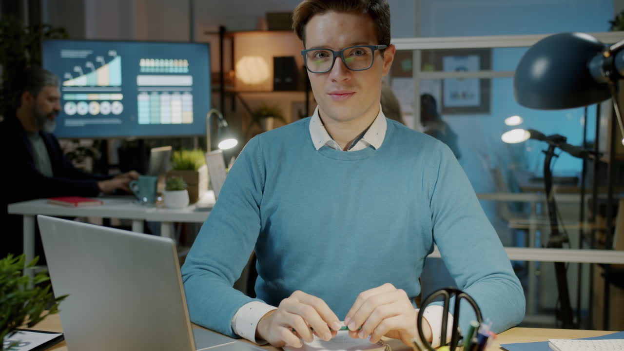 Man working on a laptop in an office at night