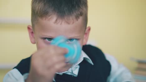 funny schoolkid turns blue spinner on blurred background