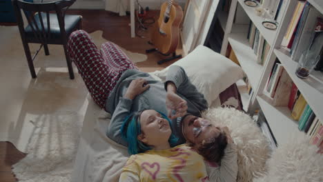 young loving couple resting on bed and smoking a cigarette