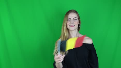 junge blonde frau schwingt die deutsche flagge vor der griechischen flagge grünen bildschirm, chroma-schlüssel hintergrund - deutsche flagge stock-video-clip-aufnahmen