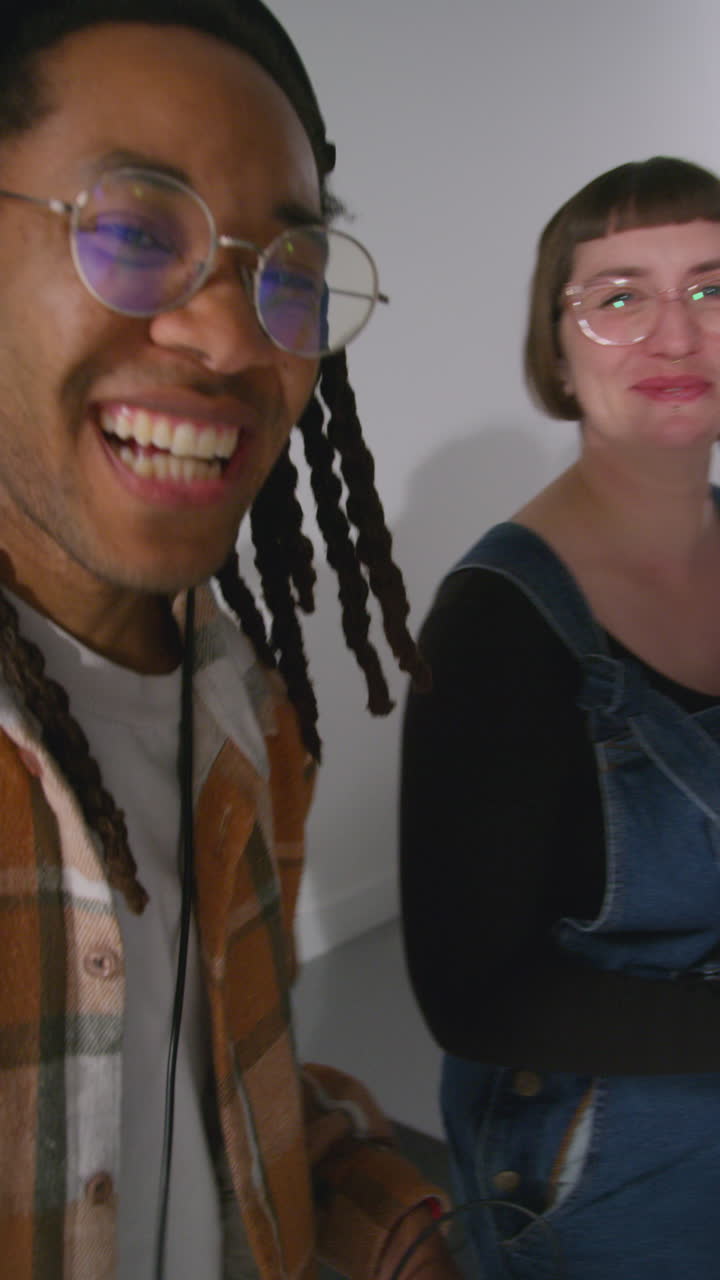 Vertical Video Of Camera Operator With Sound Recordist And Production Assistant Working On Film Set Shooting Movie Or Video In Studio Shot In Real Time