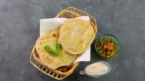 homemade corn flatbread female hand cilantro greens tomato salsa. handmade mexican tortillas vegetable salad traditional indian punjabi makki ki roti bread plate 4k wheat flour dough authentic cuisine