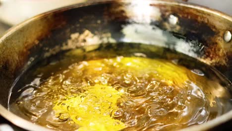 food frying in hot oil in a pan