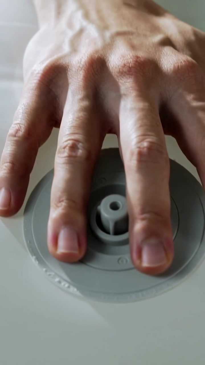 Vertical video: Placing adult bare forearm pressing grey valve to seal on white panel at home