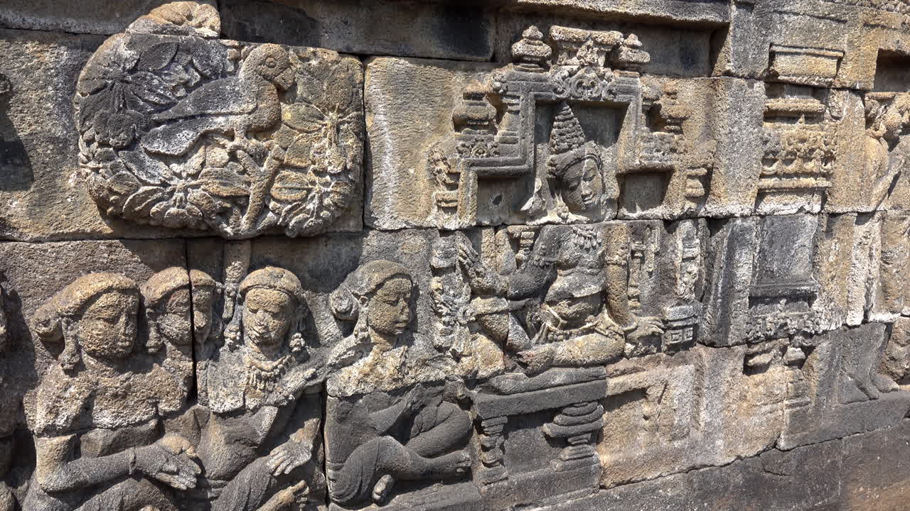 una lección de dharma ilustrada en piedra en el antiguo templo budista de borobudur.