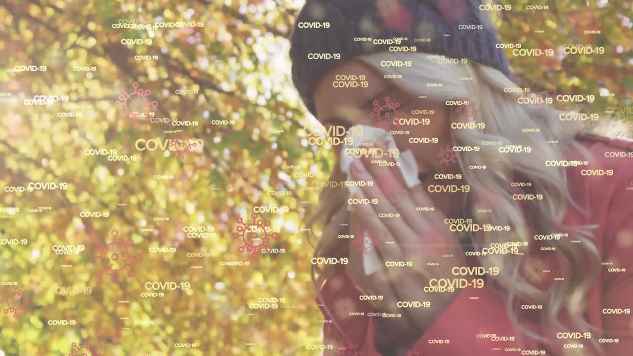 animación de las palabras covid-19 y macro células covid-19 iconos flotando sobre mujer caucásica estornudando en