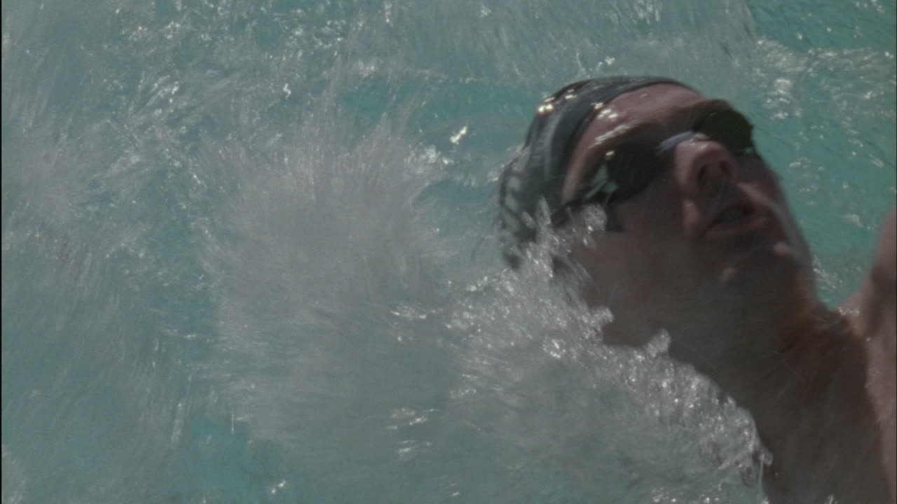 un nadador hace la espalda a través de la piscina