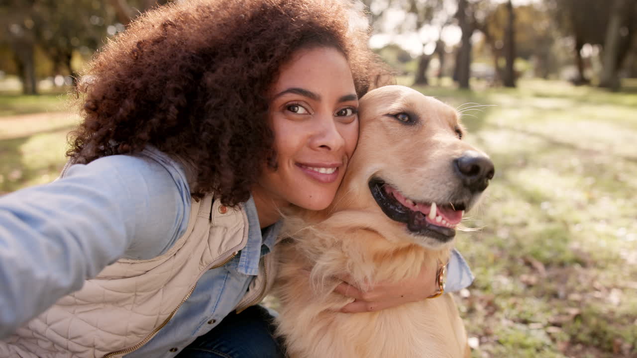 Woman hugging her Golden Retriever in the park