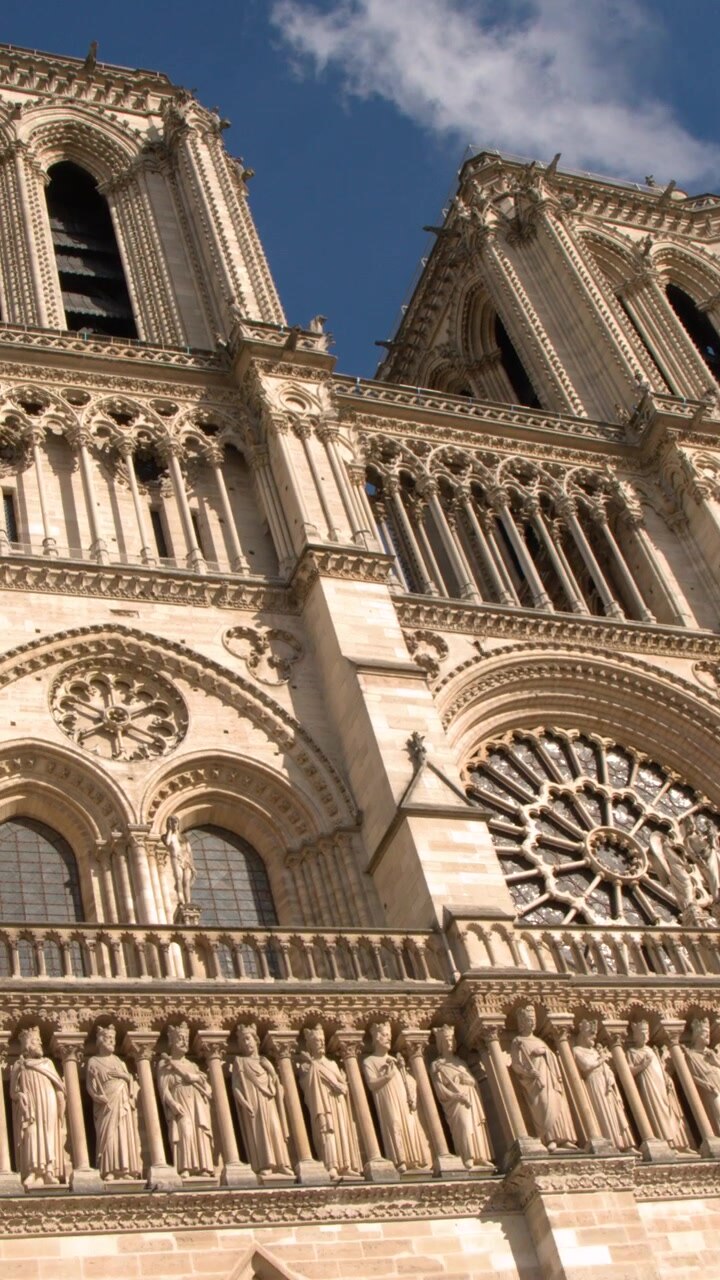 Vista dal basso della facciata in pietra ornata e delle torri della Cattedrale di Notre Dame a Parigi, Francia.
