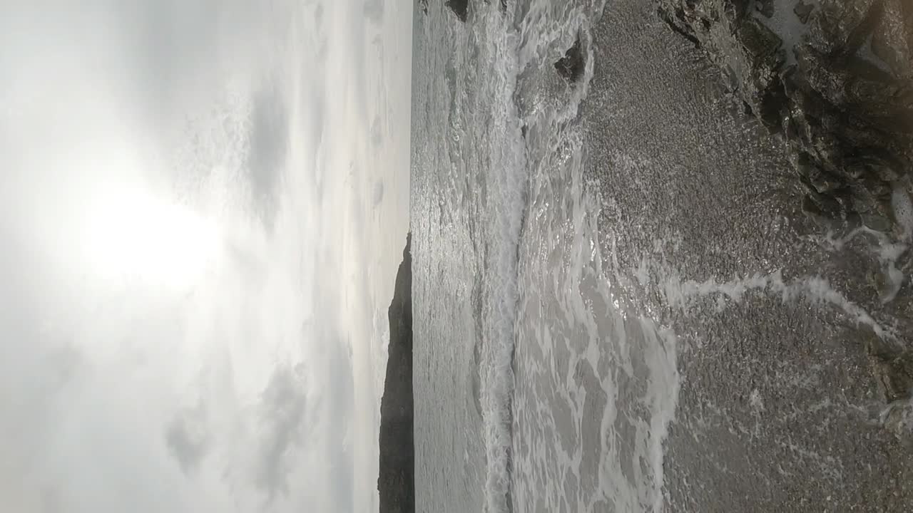 вертикальная замедленная съемка океанских волн, разбивающихся о скалистое побережье на восходе солнца