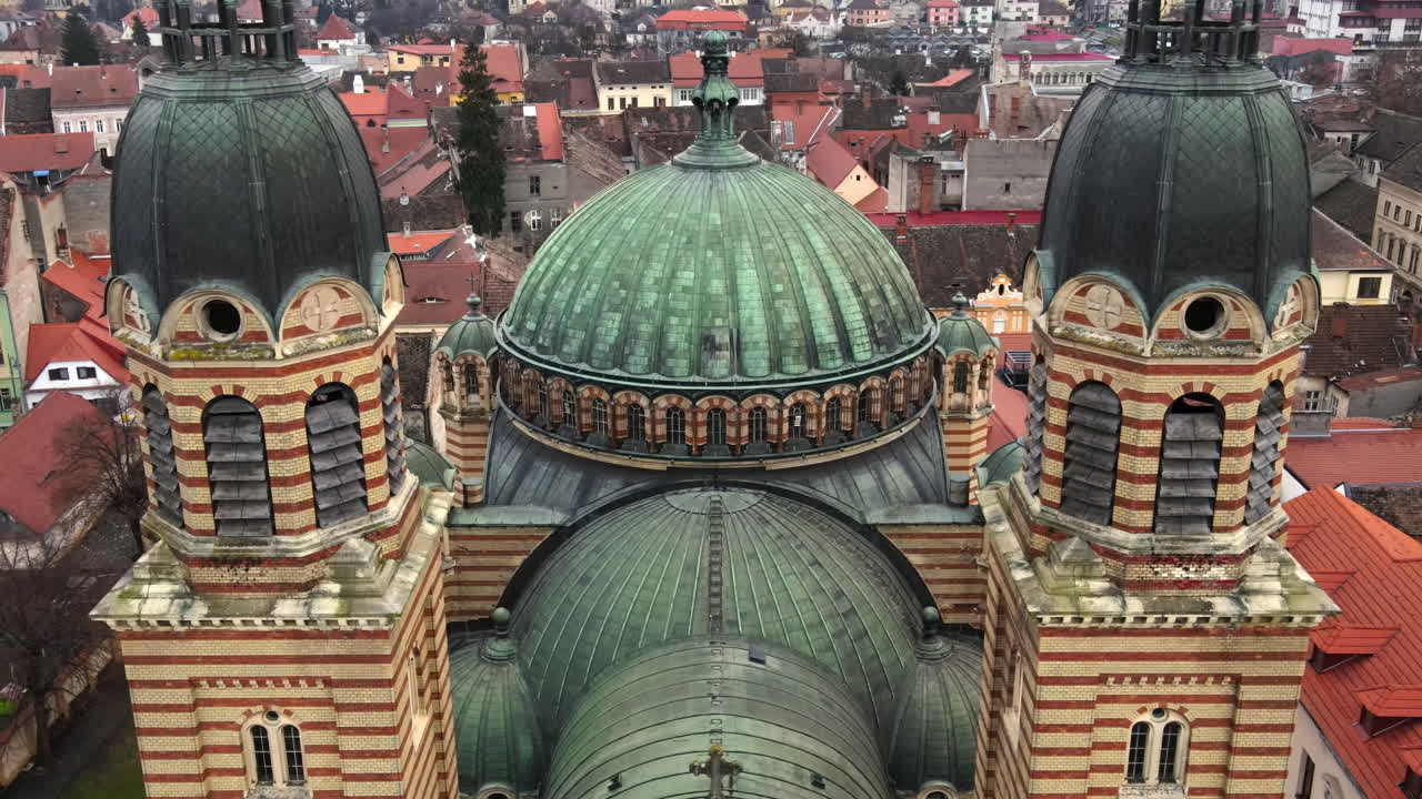 Aerial drone view of the Holy Trinity Cathedral in Sibiu, Romania. People, multiple buildings, cityscape