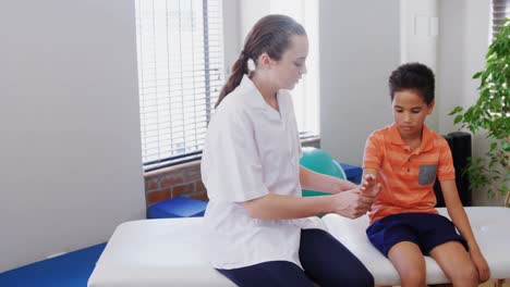 female physiotherapist giving hand massage to boy patient 4k