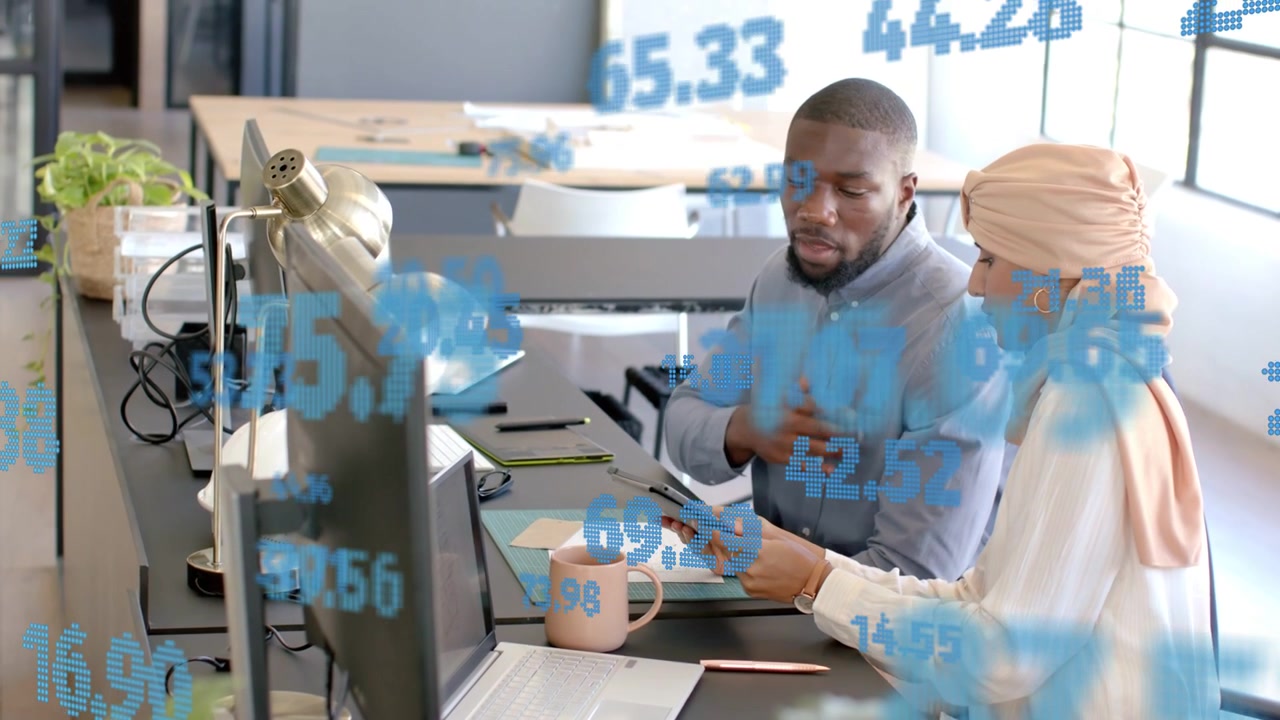 Woman showing tablet, man scrolling and analyzing finance data, blue overlay appearing over desk