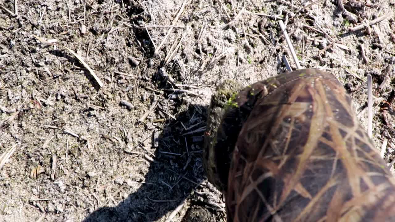 POV hunter walking in the mud and looking down