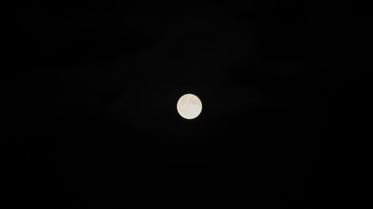 Stunning 4K video of a full moon filmed at night with telephoto lens.