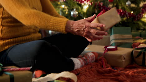 at christmas, smiling woman in santa hat enjoying holiday season by christmas tree at home