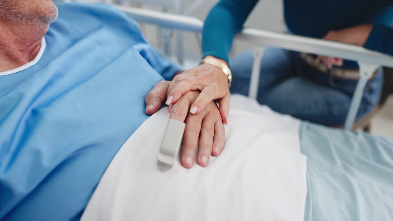 Primo piano di una persona che conforta un paziente anziano in un letto d'ospedale