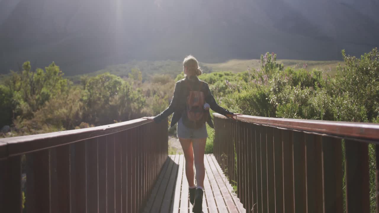 una mujer caucásica haciendo senderismo en la naturaleza.