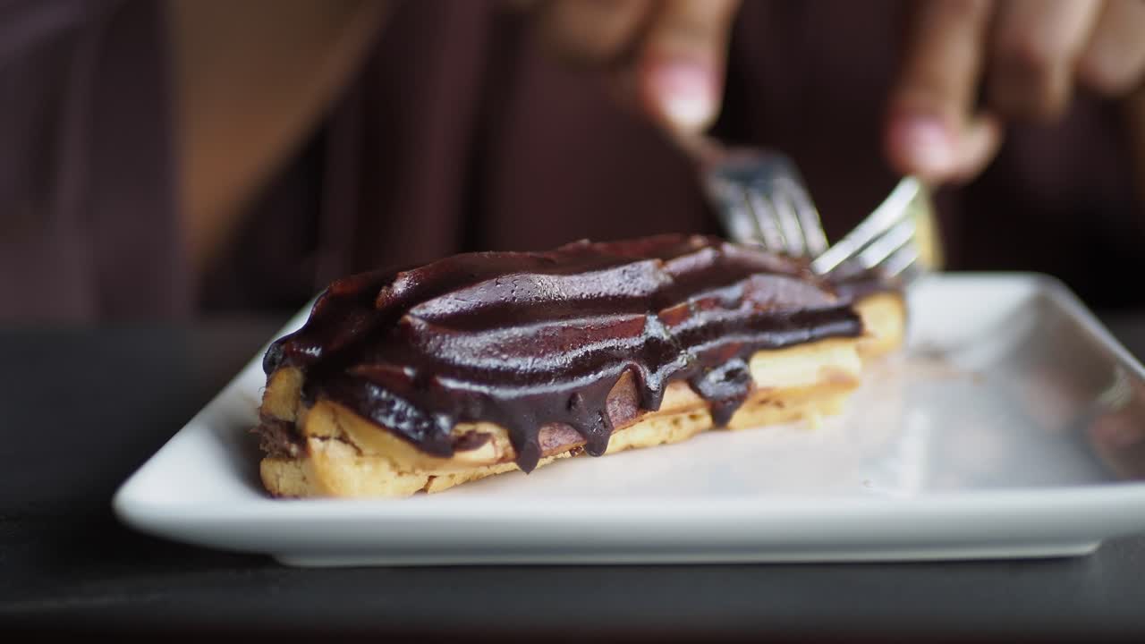 cerca de un eclair de chocolate en un plato blanco