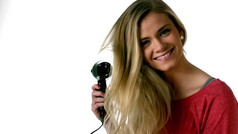 la rubia se está secando el cabello.