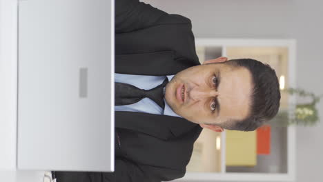 vertical video of home office worker man looking nervously at camera.