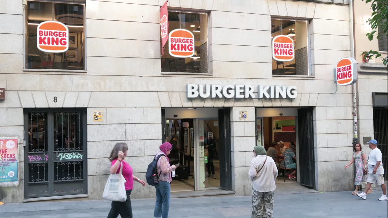 People walk past the American chain of hamburger fast food restaurants Burger King in Spain.