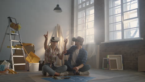 focused couple working in vr glasses indoors. family making layout in headsets.