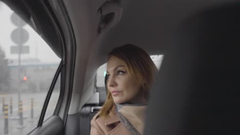 woman looking out of car window in rainy weather