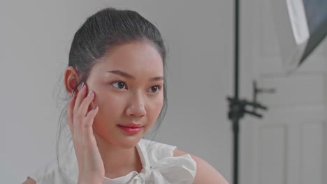 behind the scenes on photo shoot: beautiful asian model poses for a photographer