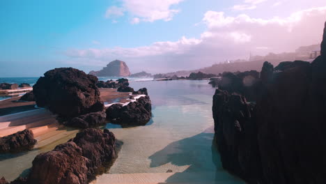 Calm-Natural-Swimming-Pools,-in-sunny-Porto-Moniz,-Madeira---Rising-POV-view