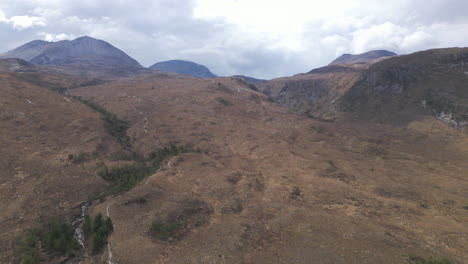 Rugged-hills-of-Beinn-Eighe,-Scotland,-under-a-cloudy-sky,-captured-from-an-aerial-view