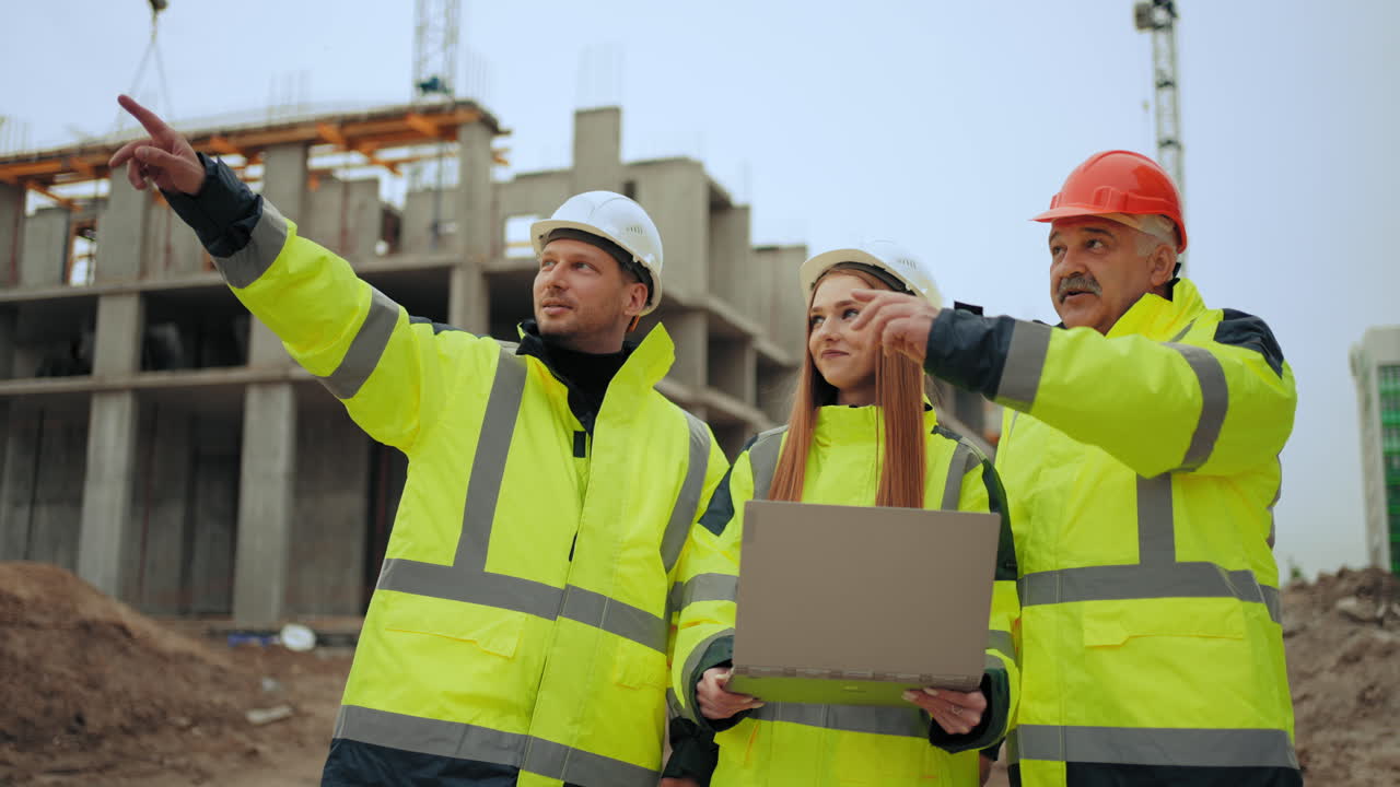 foreman and construction engineer is explaining to female architect of construction progress in building site