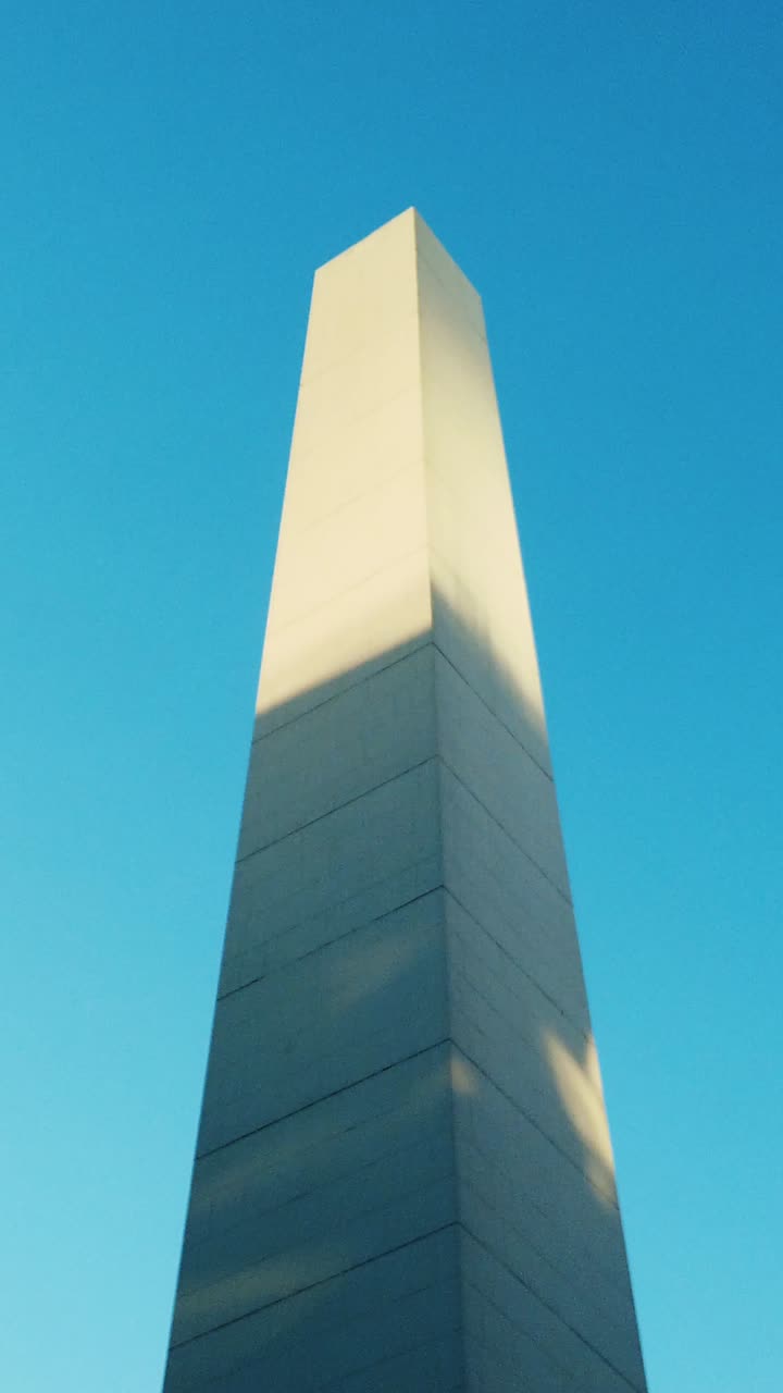 Vertical establishing overview of the Obelisk in Buenos Aires, a towering iconic monument in the heart of the city, symmetrical centered
