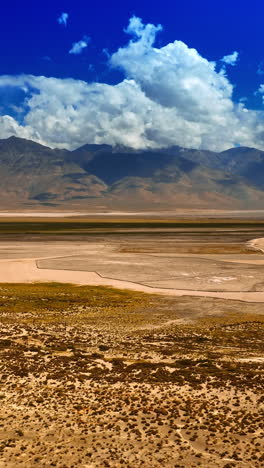 varied types of land in the desert of california. gorgeous bare rocks are at background shadowed by clouds. top view on death valley. vertical video