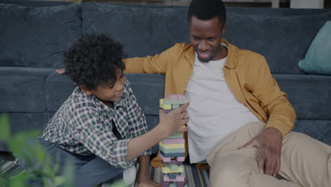 father and son playing with blocks at home