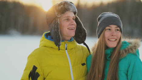 un hombre y una mujer cariñosos esquiando en el bosque invernal realizando actividades al aire libre llevando un estilo de vida saludable. camara lenta