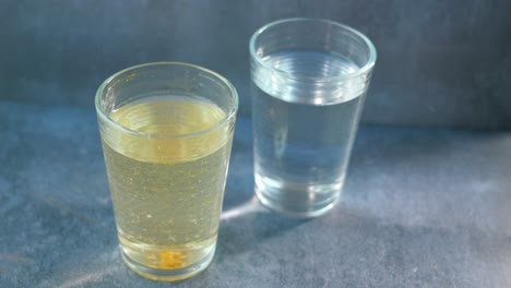 two glasses of liquids, one with a yellow substance