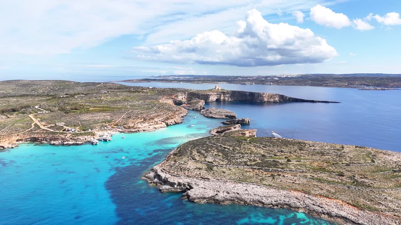 Den blå lagune i Comino, Għajnsielem, Gozo, Malta, med kalksteinsklipper og grunt turkist basseng over klart middelhavsvann med lav forurensning og minimal menneskelig påvirkning, droneoverflyvning fremover