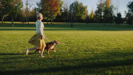 autumn walk in the park with two pets woman walking her dogs