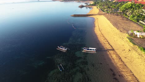 traditional indonesia boats near sandy coast during sunset, aerial view