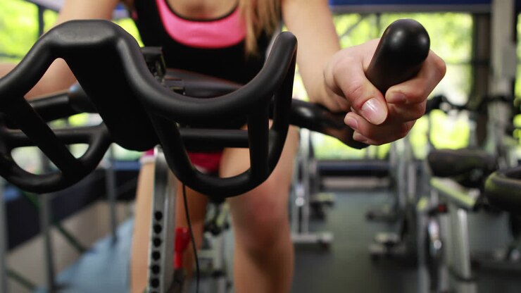 Fit woman using exercise bike