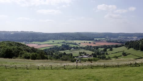 antena - la gente pasea a su perro en una colina cerca de uley, cotswolds, inglaterra, siguiendo a la derecha