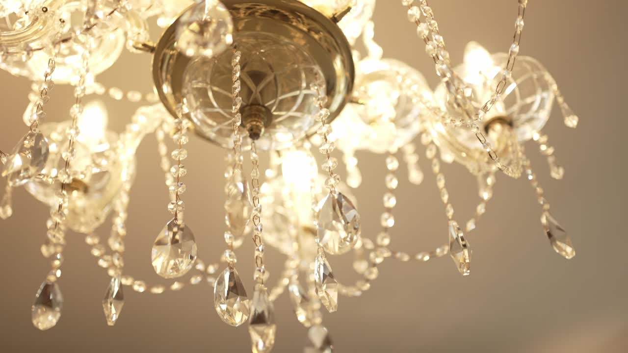 Elegant chandelier with crystal ornaments and intricate detailing, softly illuminated