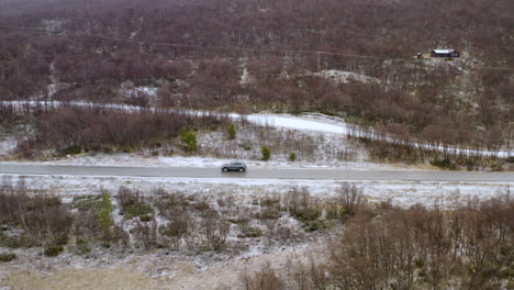 挪威冬季在多弗山 (dovre mountain) 穿過無葉樹的汽車