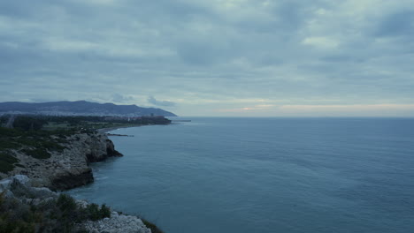 dramatic-time-lapse-shot-of-dark-blue-sky-moving-above-sea-coastline-during-early-morning