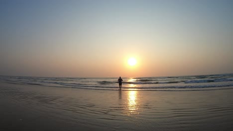 Un-Hombre-Indio-Asiático-Corriendo-Hacia-La-Puesta-De-Sol-En-Una-Hermosa-Playa-Durante-Las-Vacaciones-De-Verano