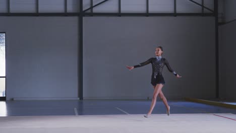 gimnasta adolescente actuando en el salón de deportes