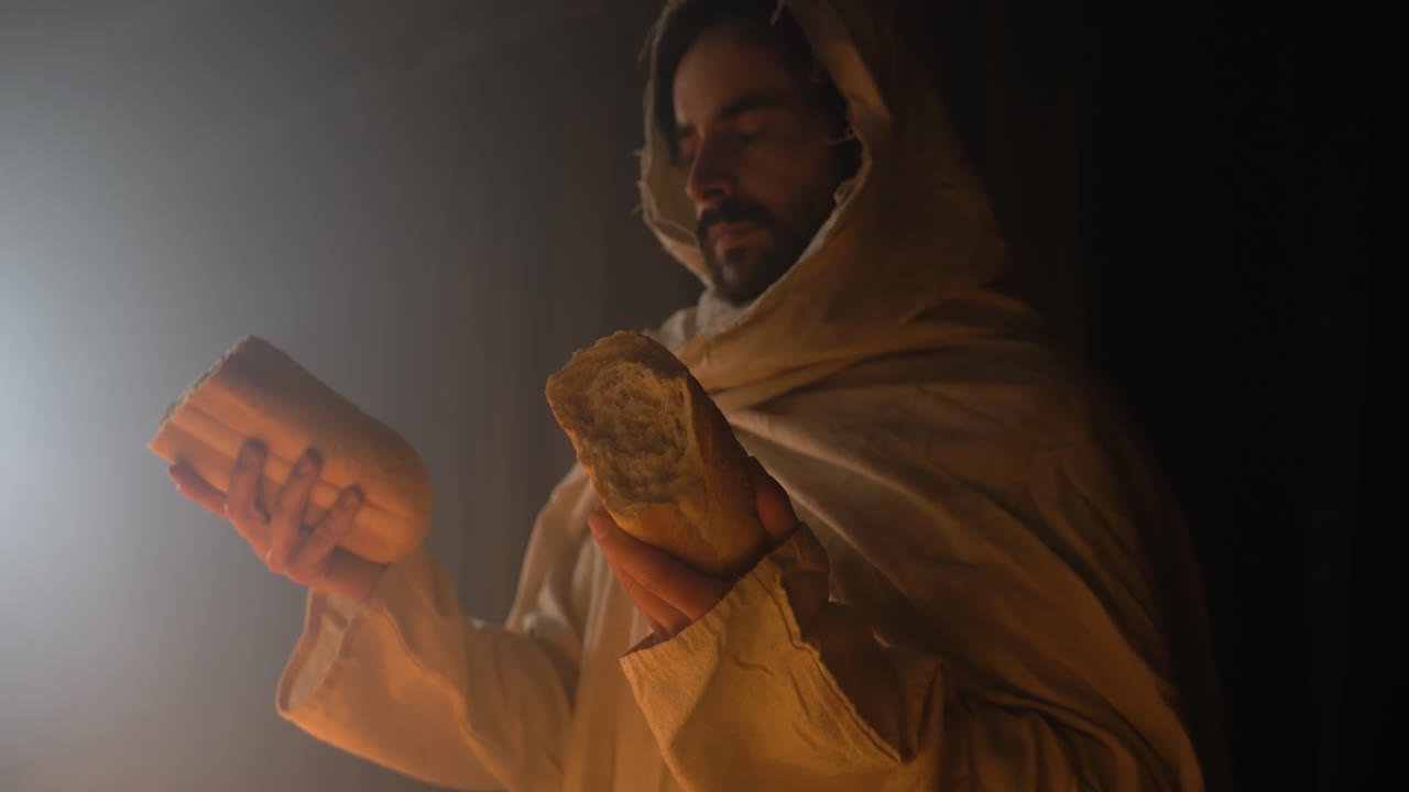 Jesus Christ in ambient light holding bread for communion, Passover, last supper for Christianity stock footage